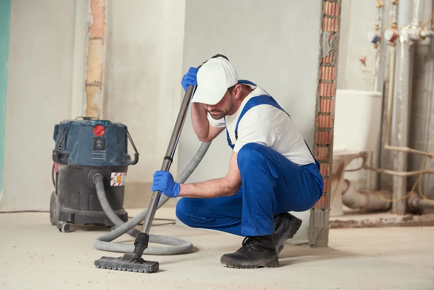 Technicien aspirant les poussières de travaux lors d’un nettoyage de fin de chantier